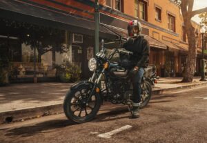 Un motociclista sentado sobre su Kawasaki W175 LTD negra en una calle de la ciudad