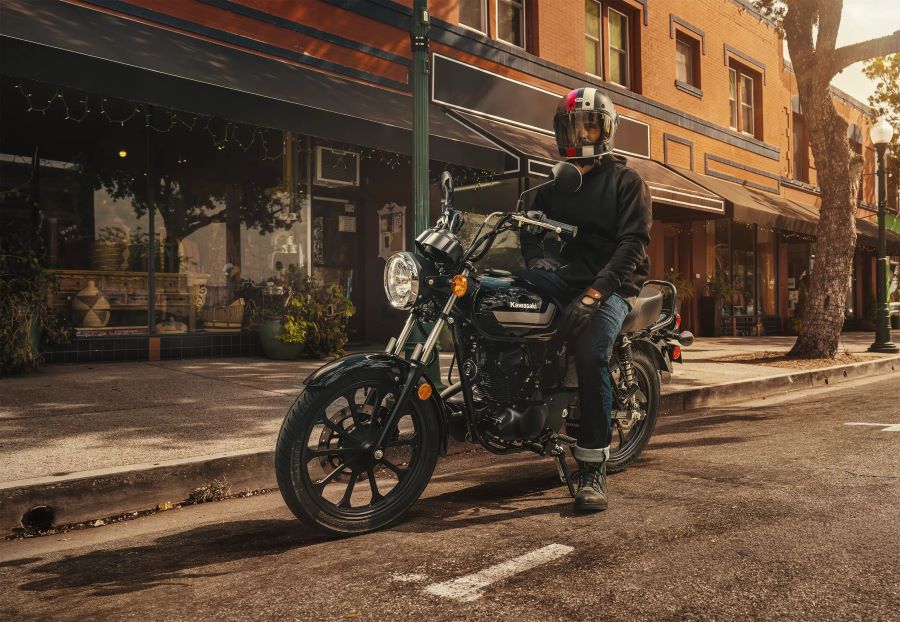 Un motociclista sentado sobre su Kawasaki W175 LTD negra en una calle de la ciudad