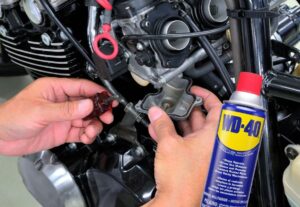 Un mecánico usa un aditivo para limpiar el carburador de una moto