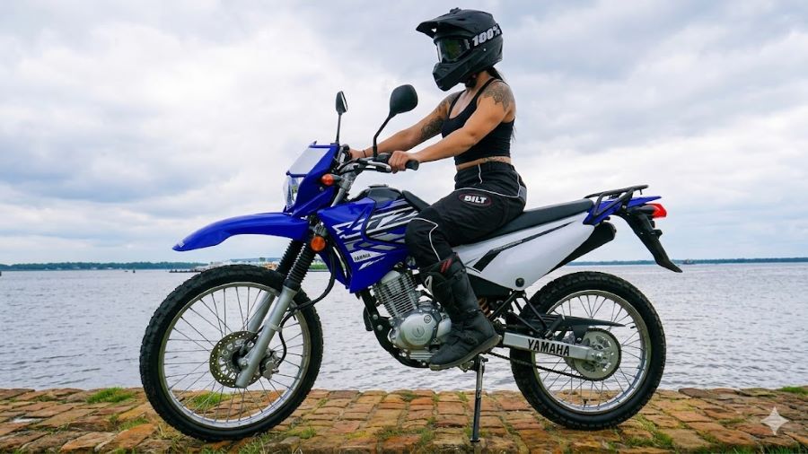 Una mujer subida a una moto Yamaha XTZ 125 azul