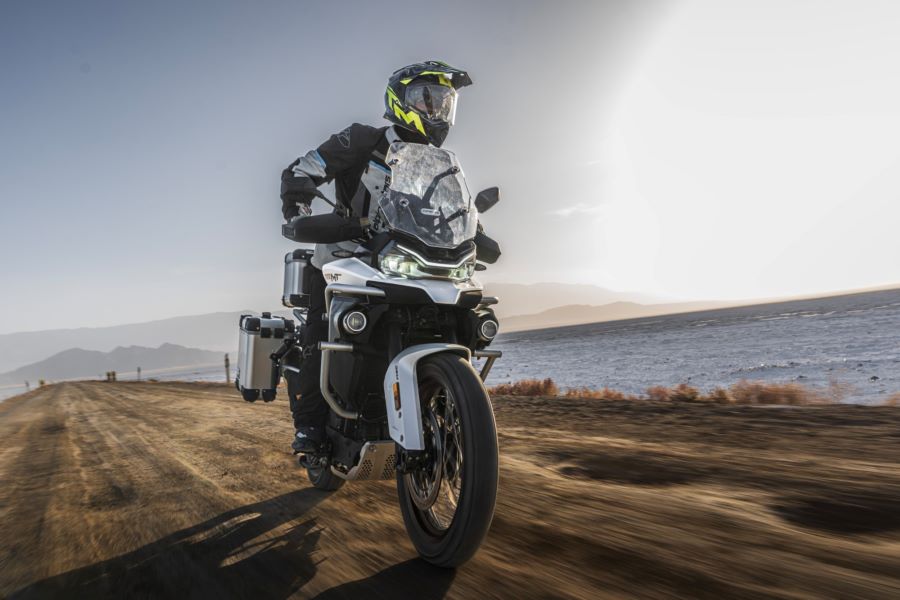 Un piloto avanza parado sobre los pedalines de una CFMoto 800MT ES con suspensión semiactiva