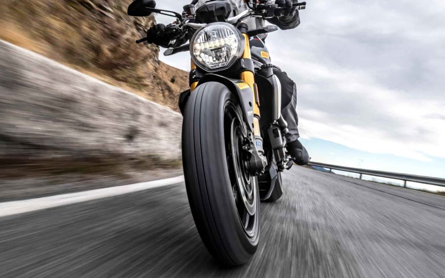 Primer plano de una rueda delantera de moto en avance