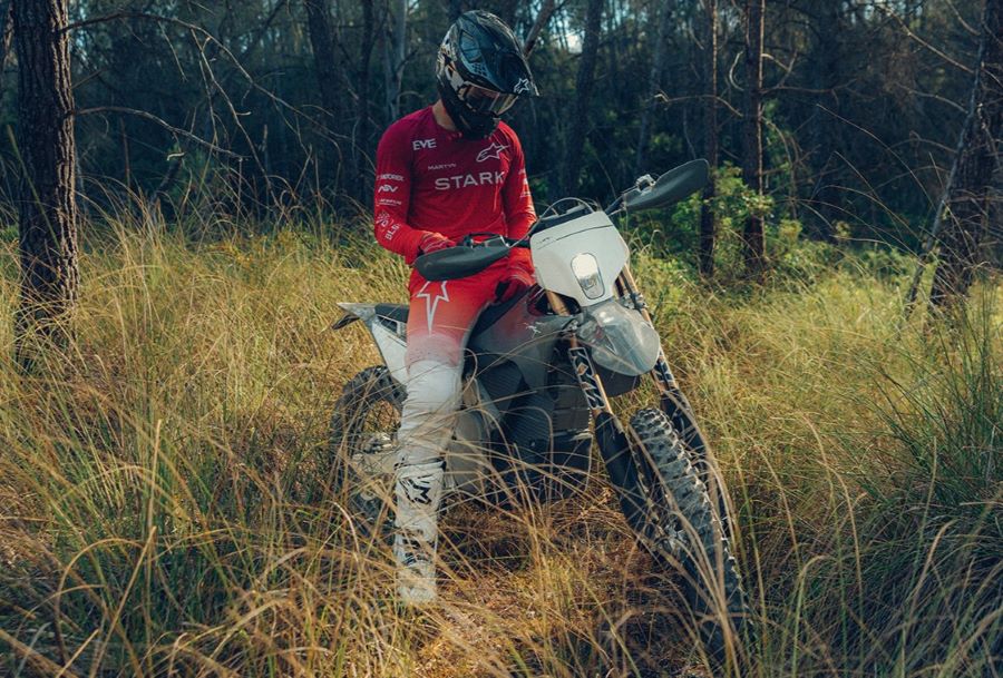 Un piloto configura su moto Varg EX Factory Edition en medio de la maleza