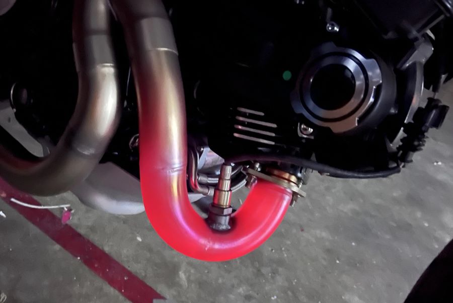 ¿Por qué el escape de mi moto se pone rojo? | Causas y riesgos curva baja de un escape de moto al rojo vivo