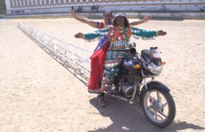 El creador de la moto más larga del mundo y su compañera posan sobre el modelo