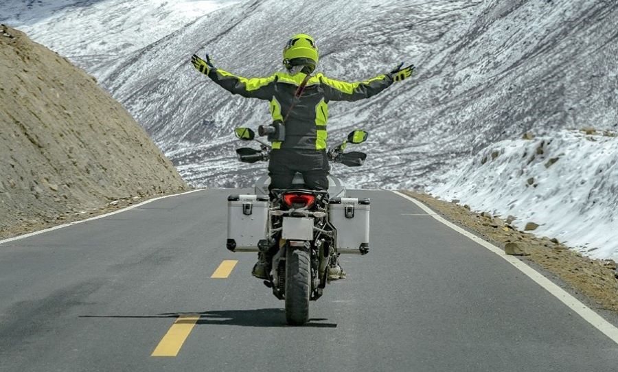 Cuánto se tarda en recorrer la Ruta 40 en moto un motociclistas se para sobre las estriberas y exteinde los brazos para disfrutar del trayecto sobre la Ruta 40