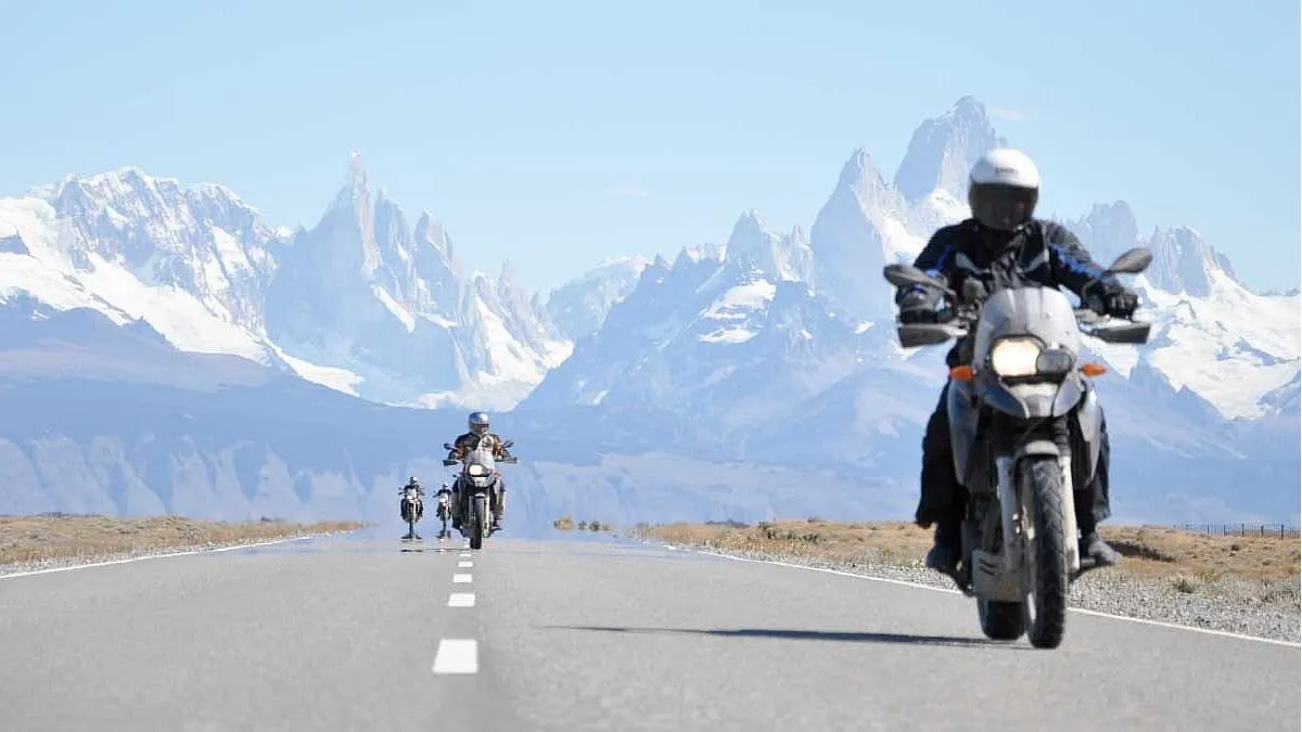 Cuánto se tarda en recorrer la Ruta 40 en moto Una caravan de motos avanza sobre la Ruta 40 con las cumbres nevadas de fondo