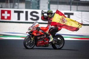 Álvaro Bautista se desplaza con su Ducati, portando una bandera española, luego de obtener una victoria