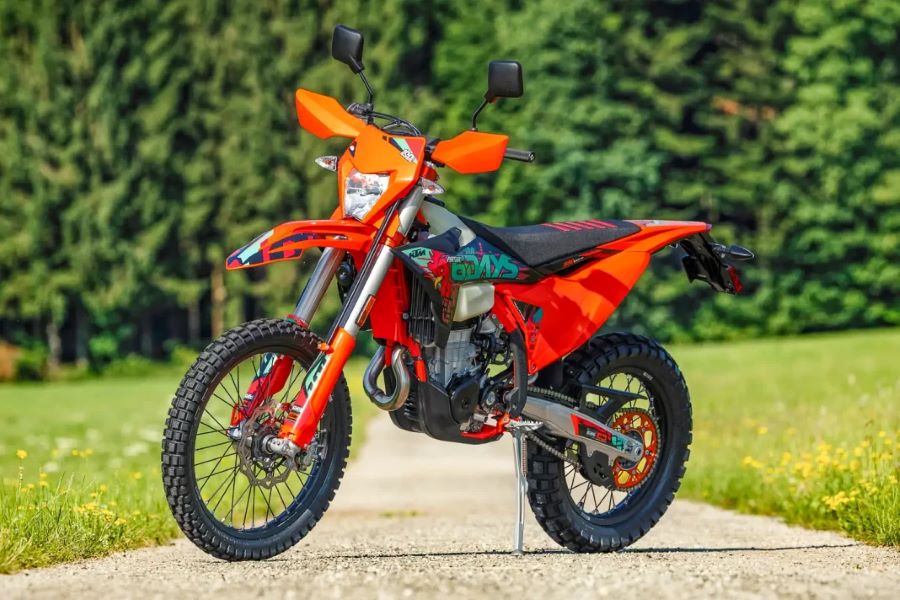 KTM 500 EXC-F 6DAYS: 100 años de enduro llevados al extremo Lateral izquierdo de una KTM 500 EXC-F 6DAYS 2027 sobre su caballete y en medio de un parque