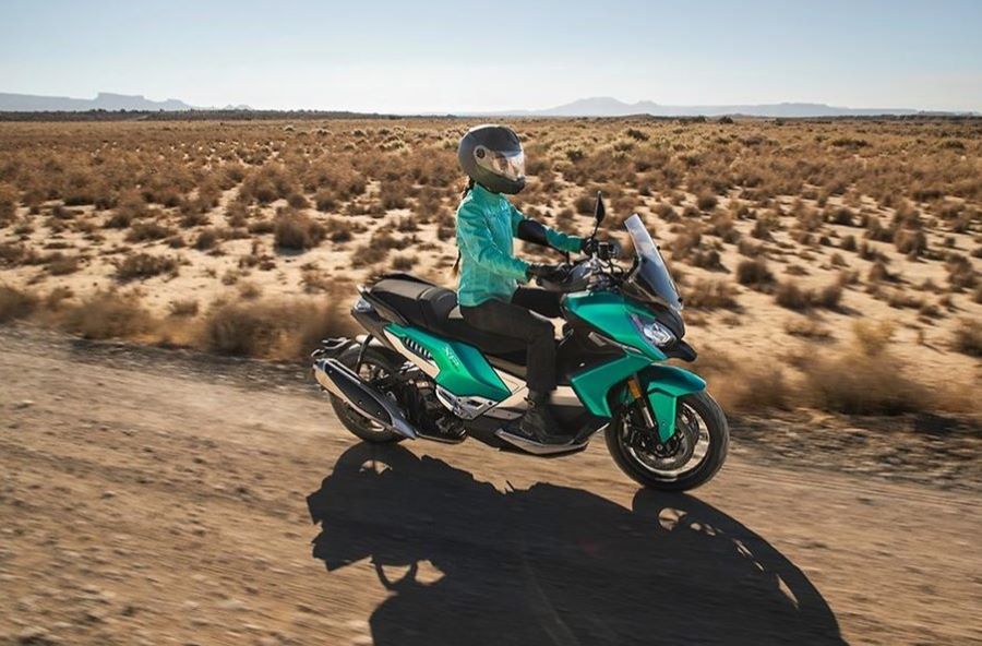 Cinco formas de entender el scooter crossover moderno Una mujer se desplaza en un scooter crossover Honda ADV350 en medio de una estepa