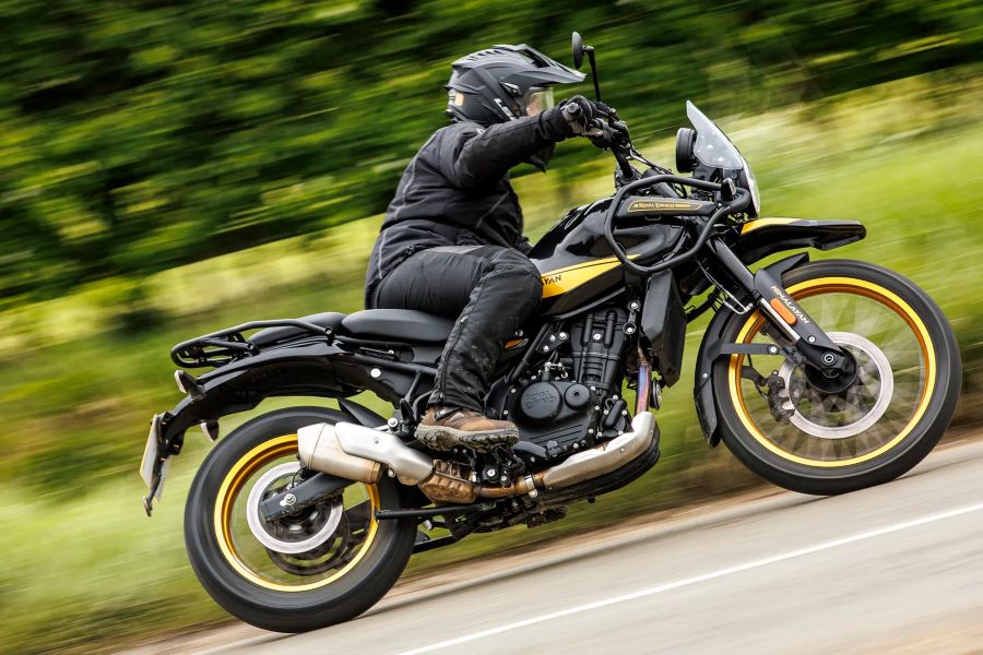 Una Himalayn 450 negra y amarilla aborda una curva en plena carretera abierta