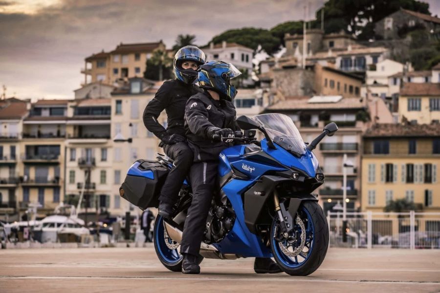 Suzuki da 8 años de garantía en Europa: ¿qué hay detrás? Una pareja seantada sobre una moto Suzuki Sport Touring observa el pasisaje