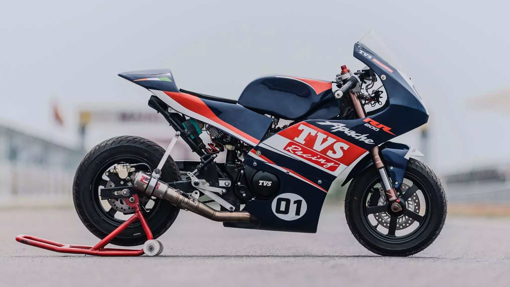 Una TVS Apache RR 200 Mini posa sobre su caballete trasero en un pista