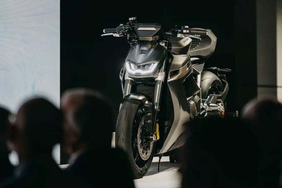 Los asistentes observan sentados la presentación de la moto Norton Manx