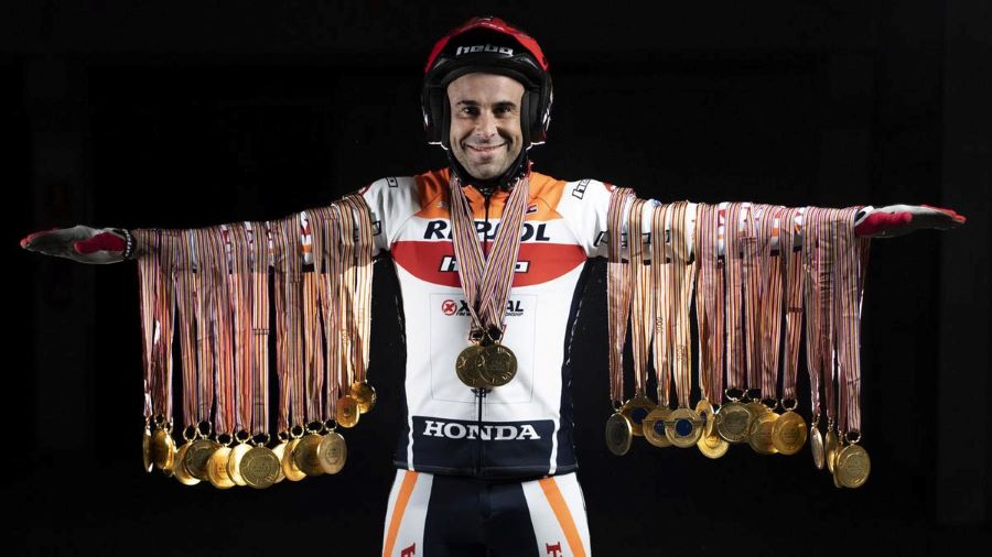 Toni Bou con los brazos extendidos y en cada uno de ellos las 40 medallas que certifican sendos campeonatos de Trial