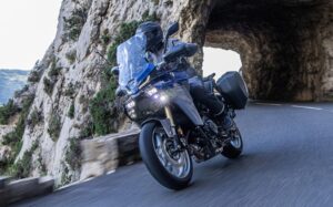 Una moto amaha Tracer 9 GT+ saliendo de un túnel de montaña