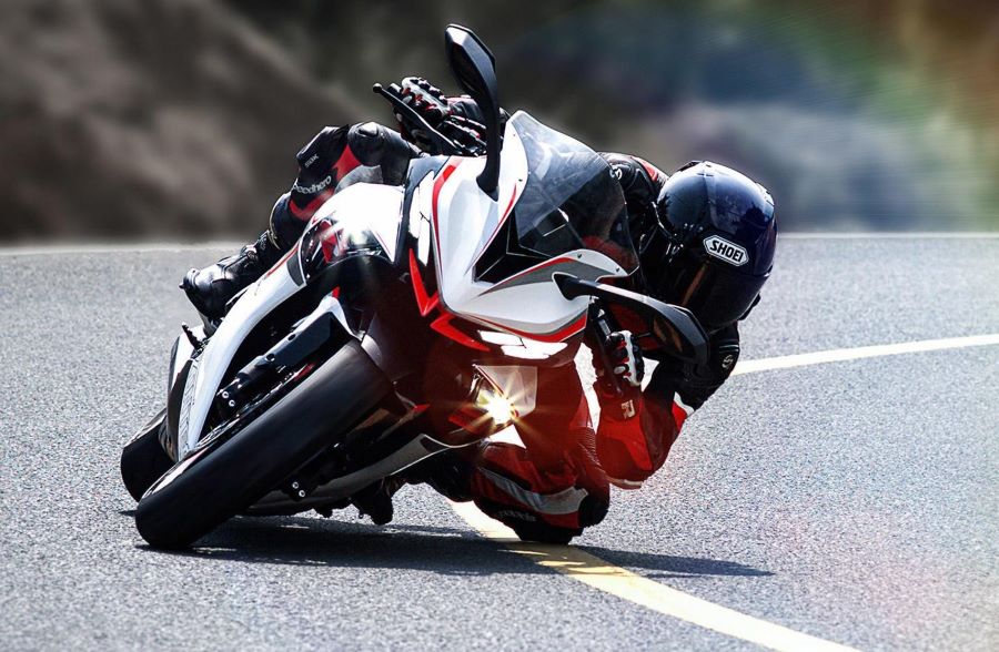 Una Zontes 703 RR viene de frente, inclinada hacia la izquierda y con las luces encendidas