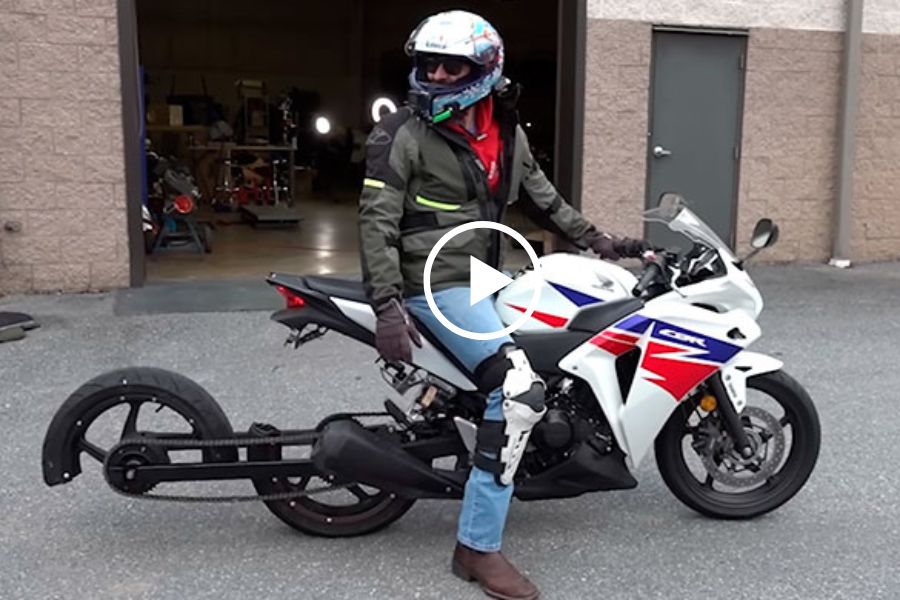 Un motociclista subido a un veh{iculo cuya rueda trasera está dividida en dos partes