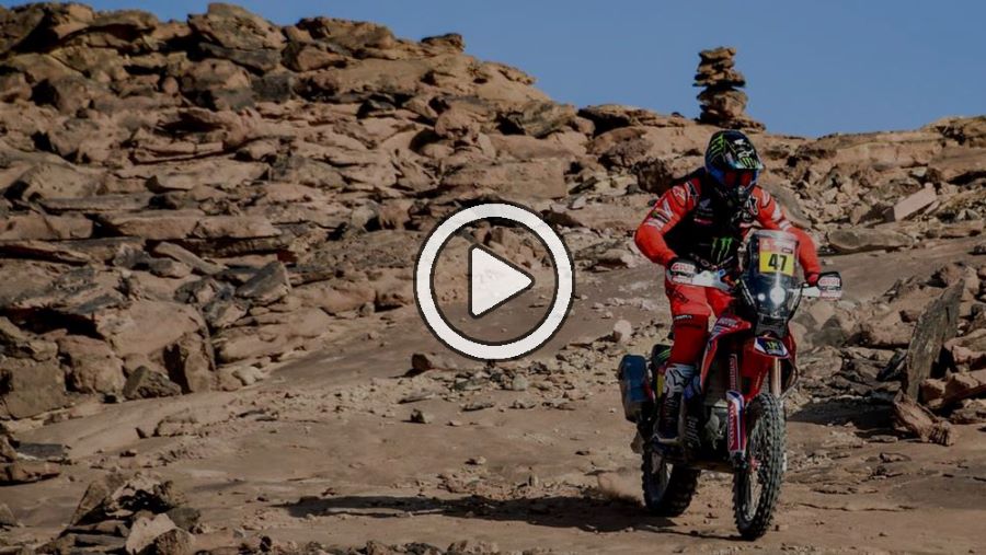 Un motociclista transita una zona desértica sobre una moto trail roja