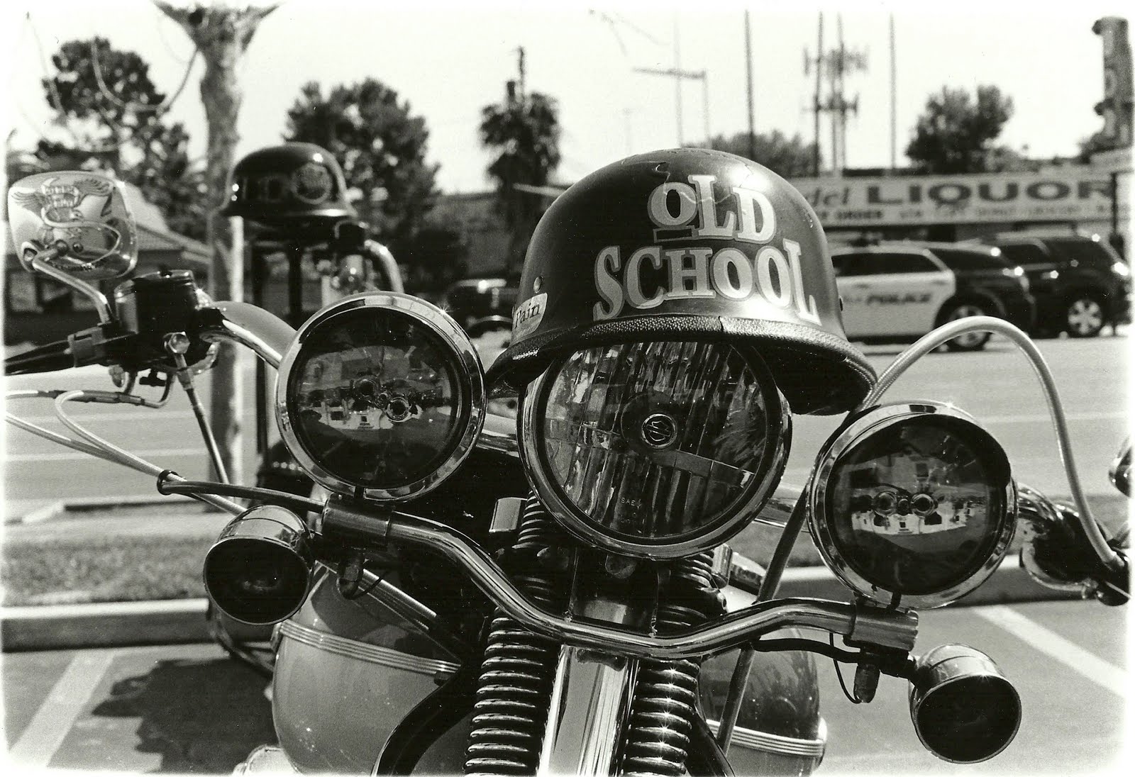 Un casco con la leyende "Olds School" descansa sobre un faro de moto 