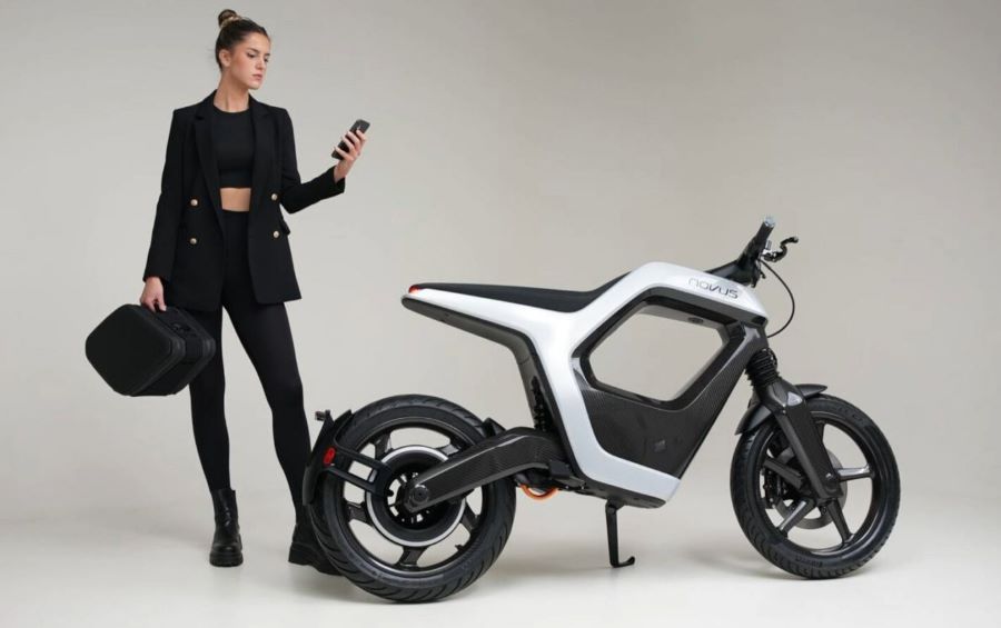 Novus One: carbono, 25 kW y una idea difícil de encasillar Una modelo, vestida de negro y conel celular en la mano, posa a un costado de una moto eléctrica Novus One blanca