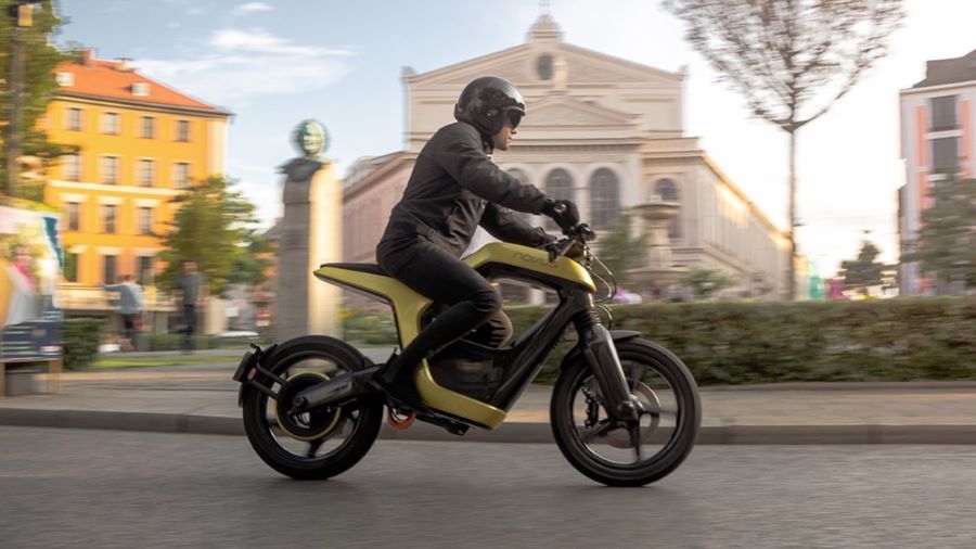 Novus One: carbono, 25 kW y una idea difícil de encasillar Un motociclista transita por una ciudad sobre su moto eléctrica Novus One dorada