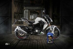 Una moto Benelli 180S blanca y a su lado un envase de aceite