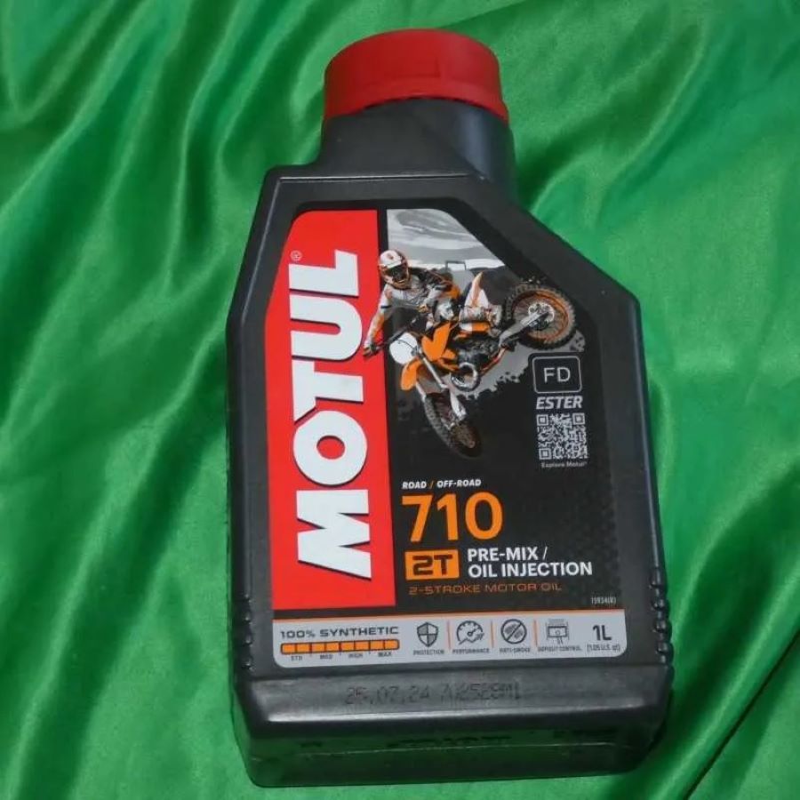Un envase de aceite Motul sobre un lienzo verde