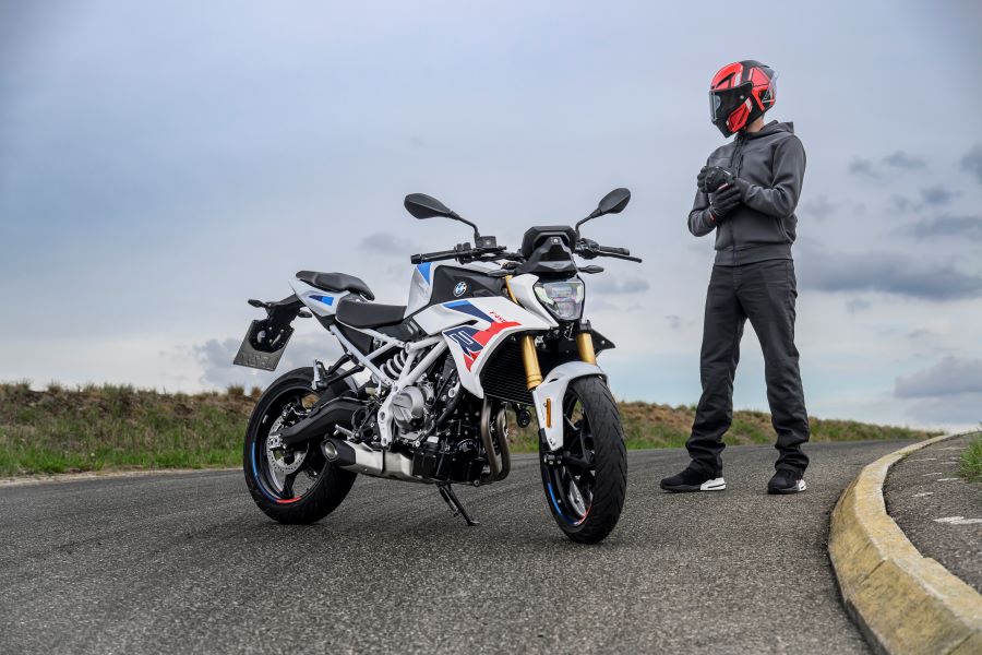 Un piloto posa al lado de una BMW F 450 R