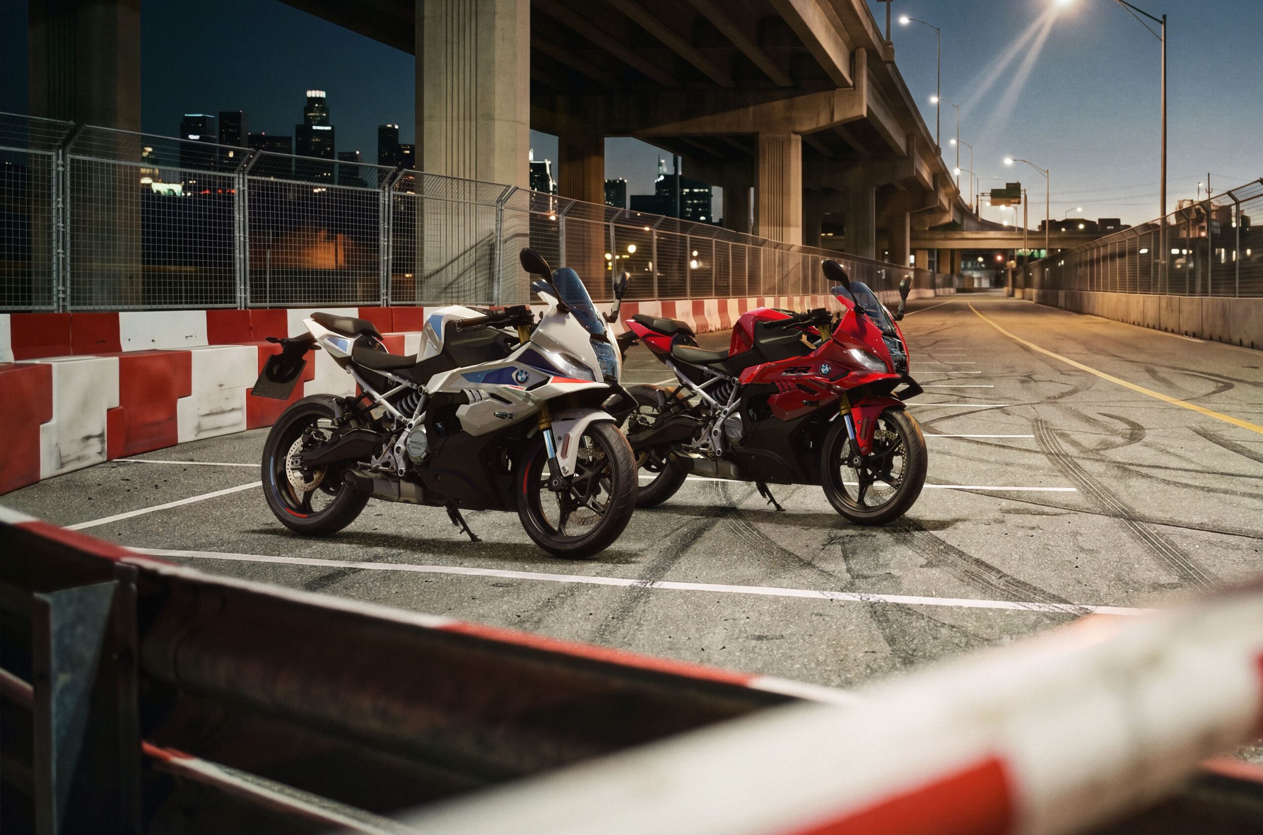 Dos BMW F 450 RR en colores blanco y rojo posa debajo de un puente de autopista