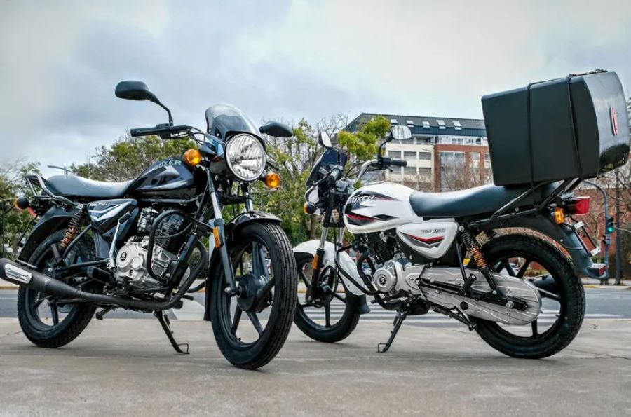 Dos motos Bajaj Boxer 150, una de ellas con caja en el portaequipajes