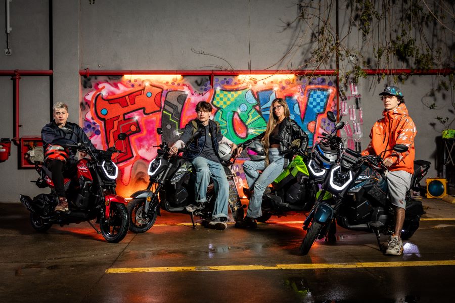 Un gfupo de jóvenes posan subidos a sus Corven Flow 150 frente a paredes con grafitis