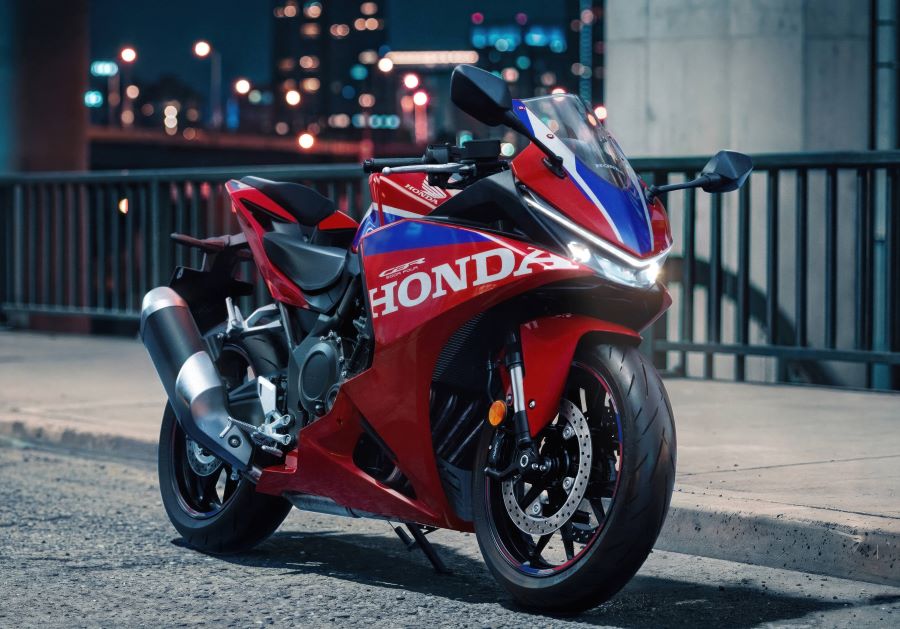 Una Honda CBR500R FOUR posa de noche y con una ciudad de fondo