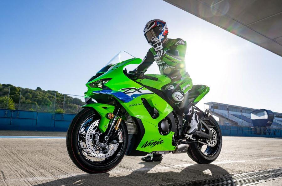 Un piloto se acomoda el casco antes de salir a pista con una moto Kawasaki deportiva