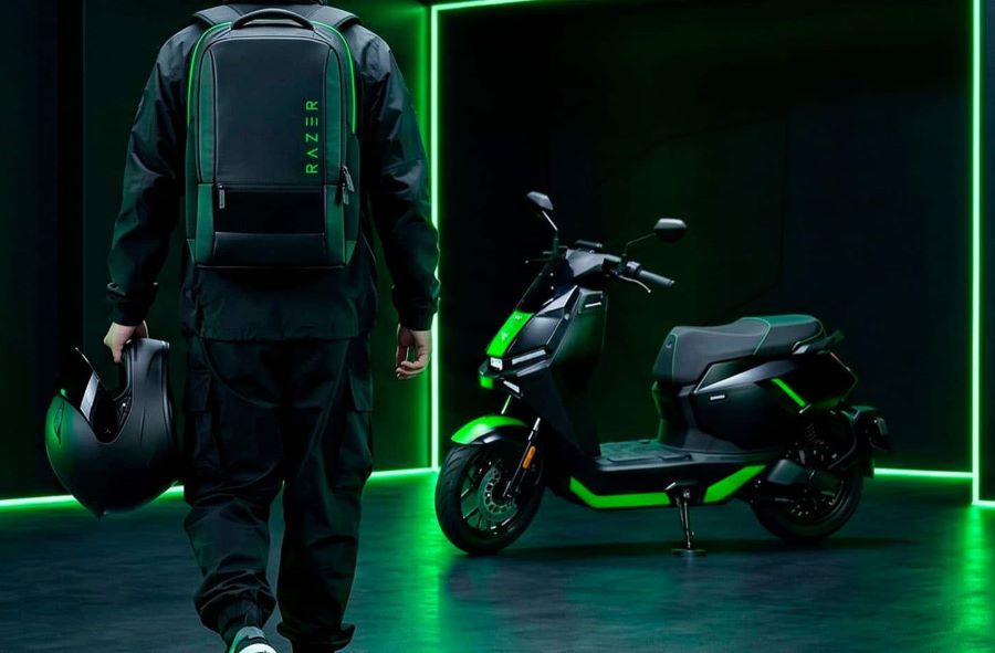Un joven que carga en su espalda una mochila con una consola Razer, se acerca a una NIU FQiX 150 Razer