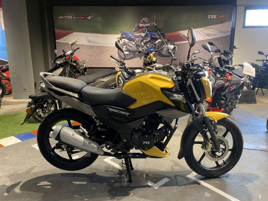 Lateral derecho de una moto TVS Rider 125 amarilla
