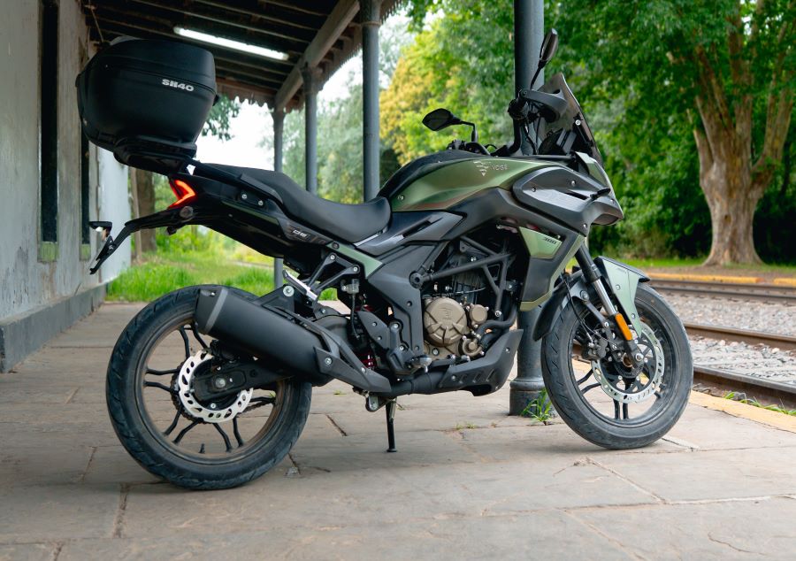 Una moto Voge 300DS posa debajo de una galería rural