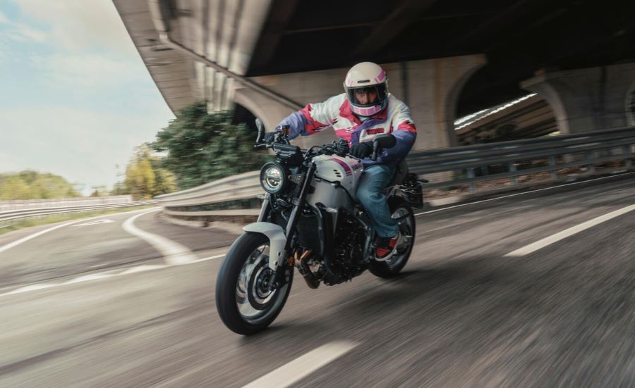 Una Yamaha XSR900 2027 gira a la izquierda en una autopista debajo de un puente