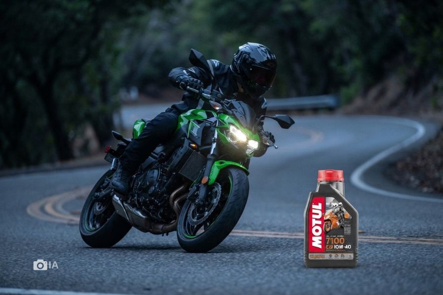 Una moto Kawasaki Z500 encara unca curva. Debajo, a la derecha de la imagen, un pote de aceite.