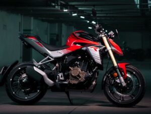 Una moto Hero Hunk 250 R roja posa en el interior de un espacio oscuro